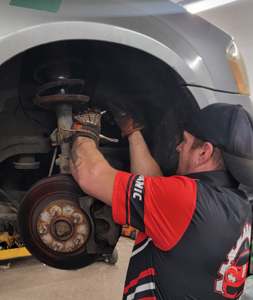 Awto Works Complete Auto Repair technician working on tire disk